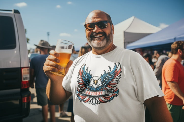 Bearded man wearing a patriotic eagle t-shirt while holding a beer at an outdoor festival. Designed for patriots, truckers and bikers alike and available in plus sizes.