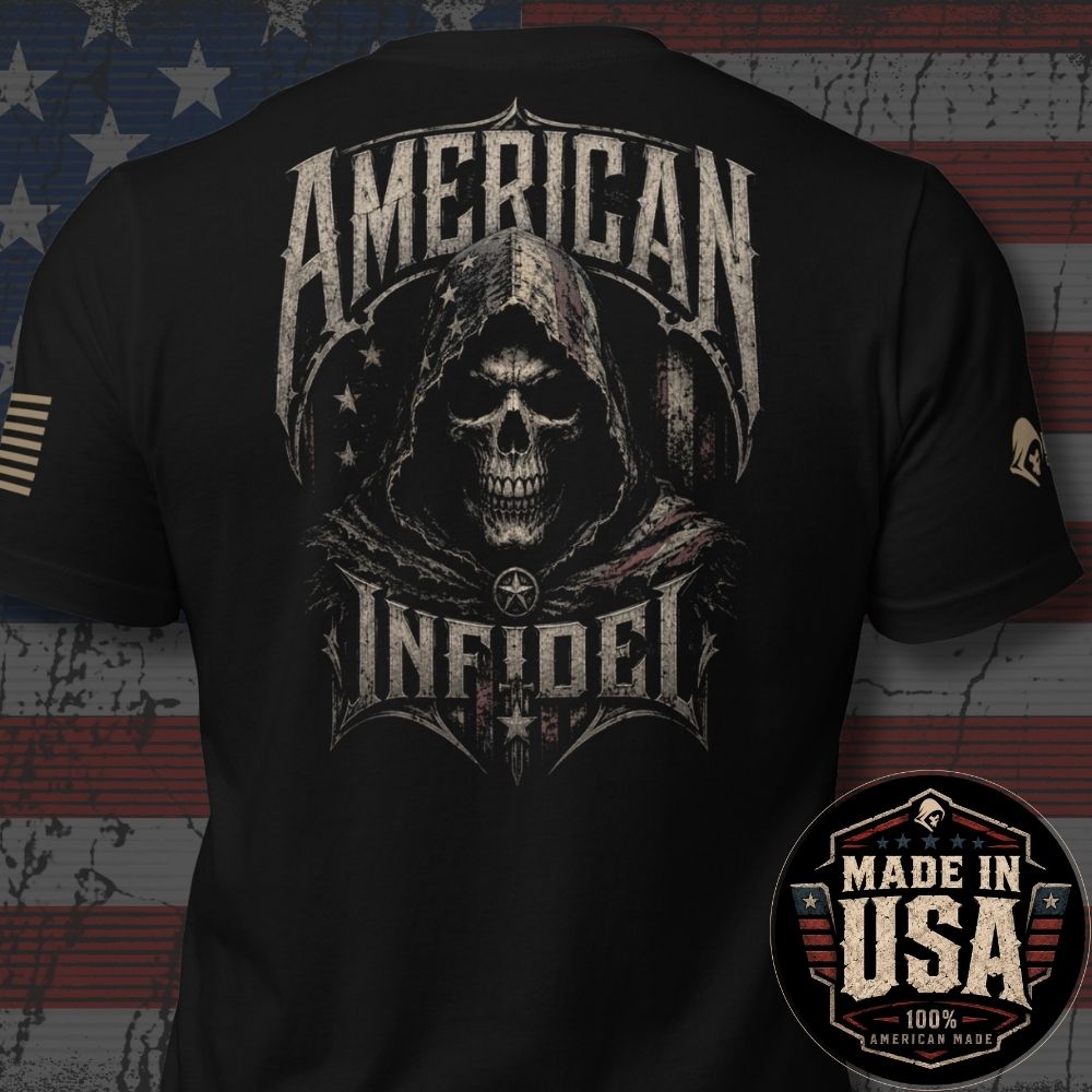 Black short-sleeve graphic T-shirt shown from the back, featuring a large distressed hooded skull design with the words “AMERICAN INFIDEL.” The shirt is photographed against a rustic American flag background, with a circular “Made in USA 100% American Made” badge overlaid in the lower right corner.