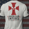A light heather gray t-shirt shown from the back, featuring a large red Iron Cross with a skull design, the words 'AMERICAN INFIDEL' in black, and 'EPHESIANS 6:10-18' printed below. The shirt is displayed against a distressed American flag background.