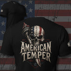 Black tee with back print featuring an American flag skull, Statue of Liberty torch, dagger graphic, and the text American Temper