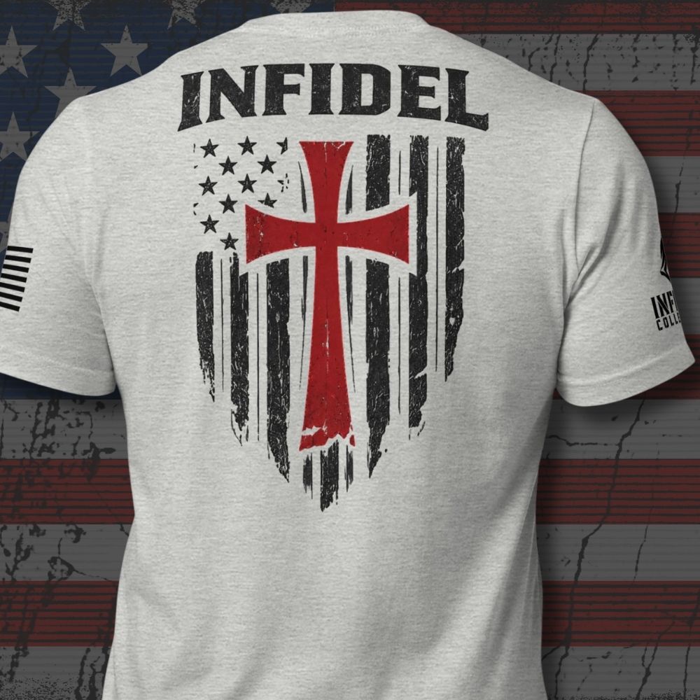 A light heather gray t-shirt shown from the back, featuring a large graphic print with the word 'INFIDEL' in black above a distressed American flag design with a prominent red cross.