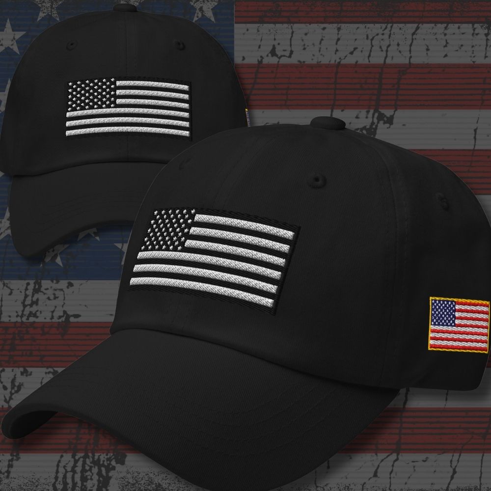 Two black baseball caps with embroidered American flag patches, shown against a distressed American flag background. The front cap is larger and in focus, while the second cap is slightly behind it and out of focus.