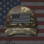Camouflage cap with American flag patch on an American flag background