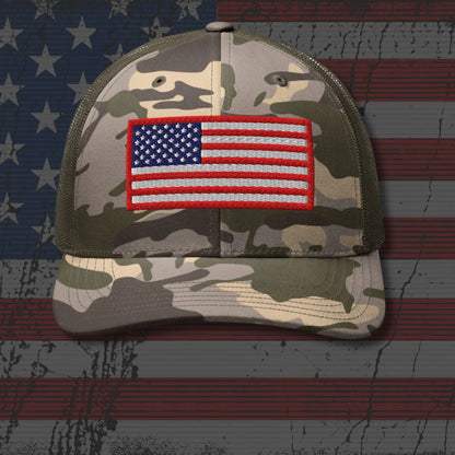 Camouflage cap with American flag patch on a background resembling the American flag.