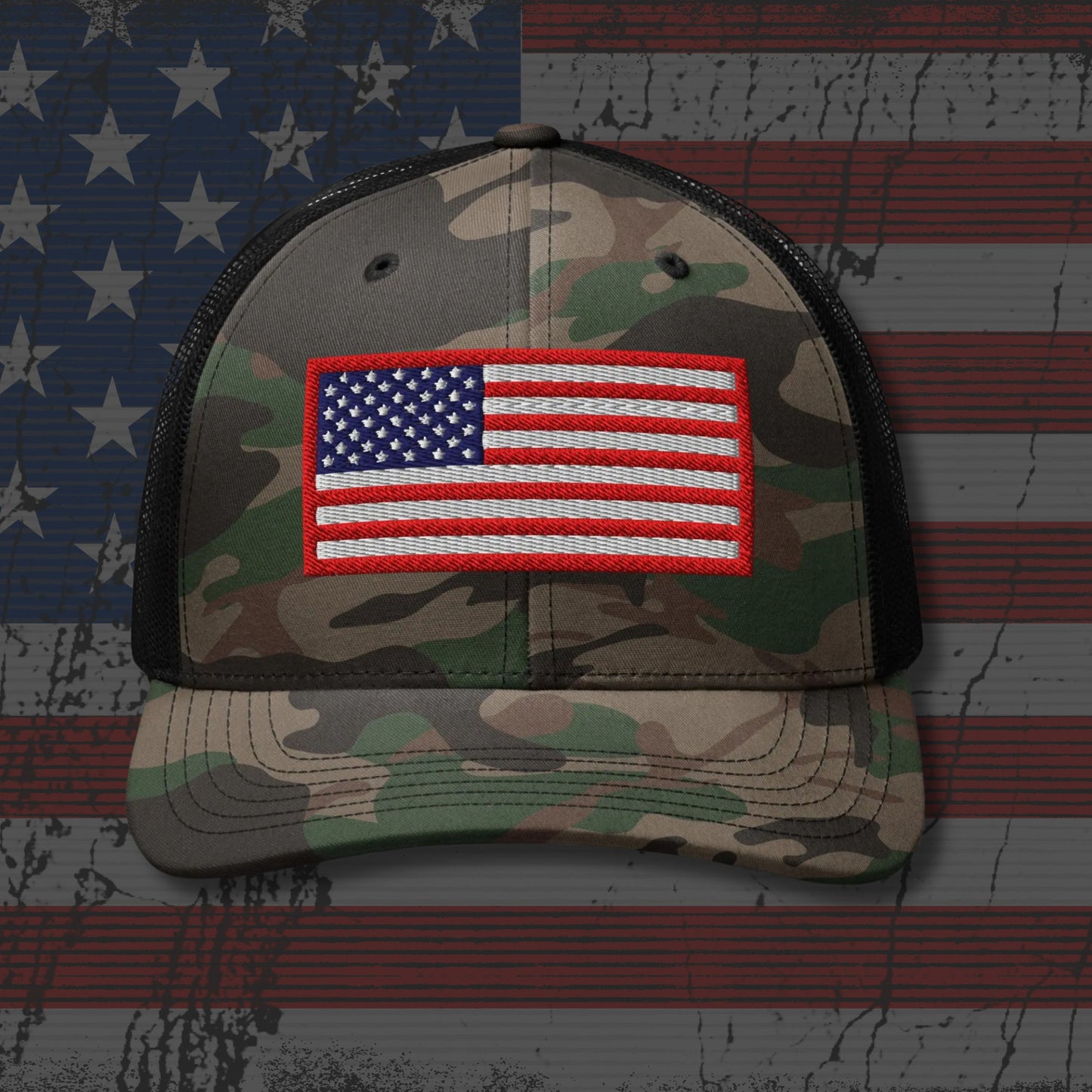 Camouflage cap with American flag patch on a background resembling the American flag.