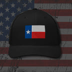 Black cap with Texas flag patch on an American flag background