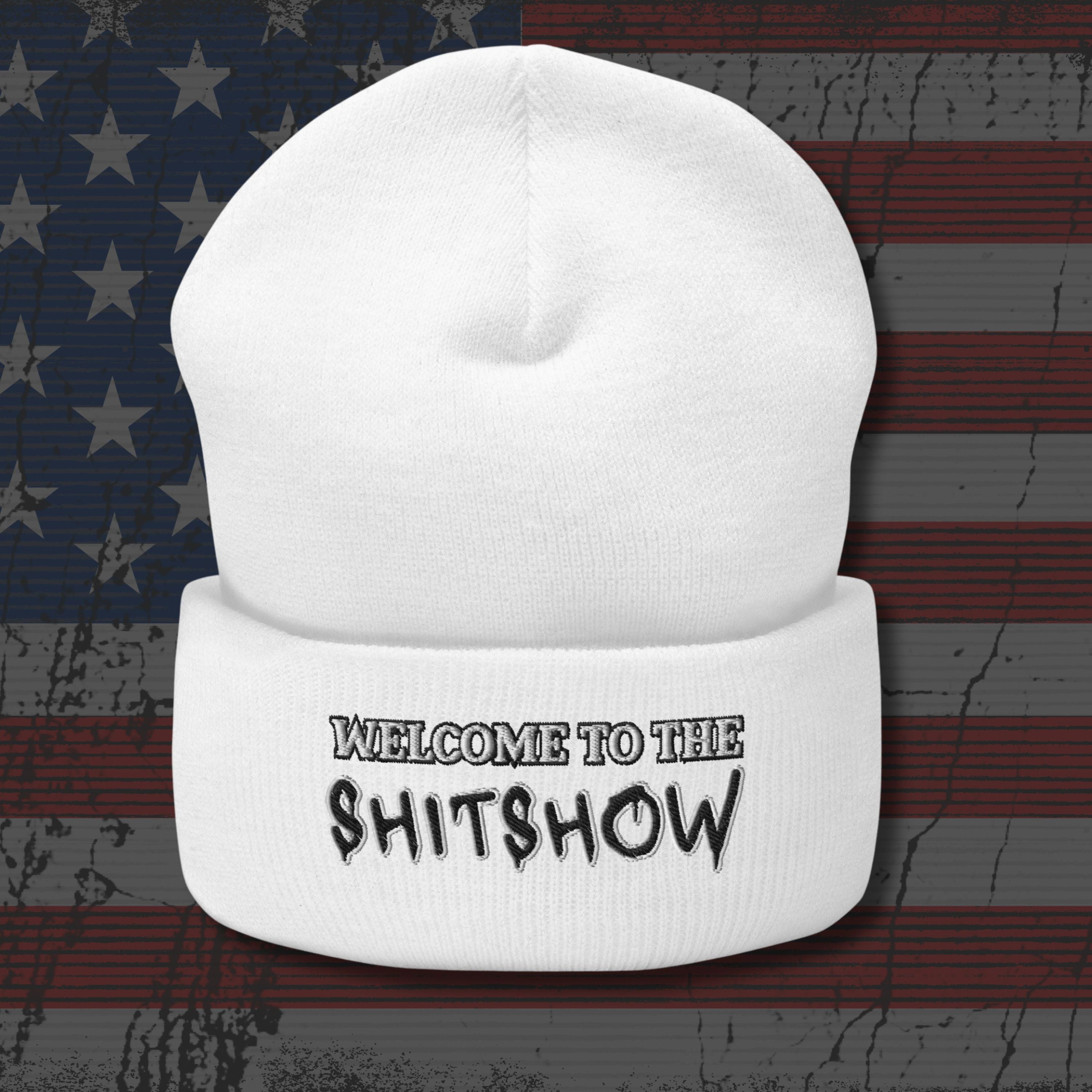 White beanie with 'WELCOME TO THE SHITSHOW' text on an American flag background