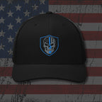 Black cap with a blue and white emblem on an American flag background