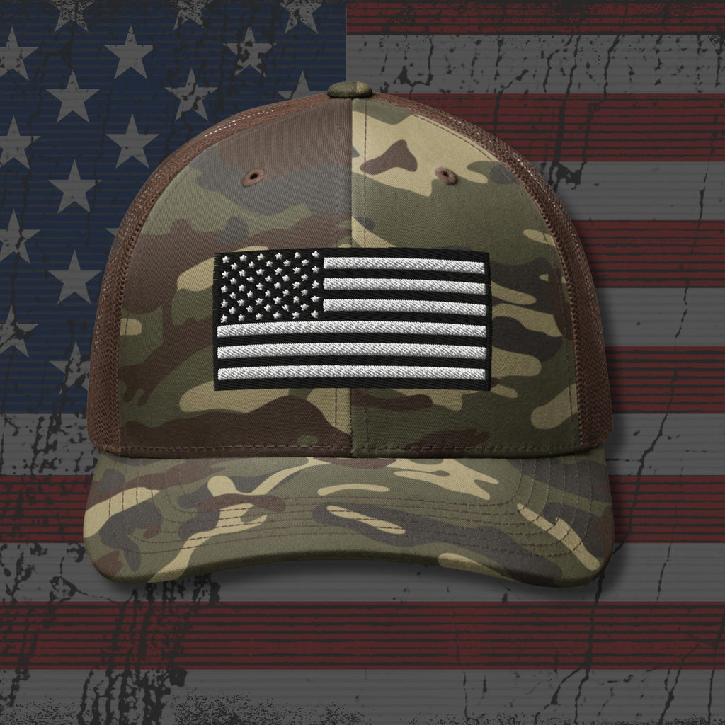 Camouflage cap with American flag patch on an American flag background