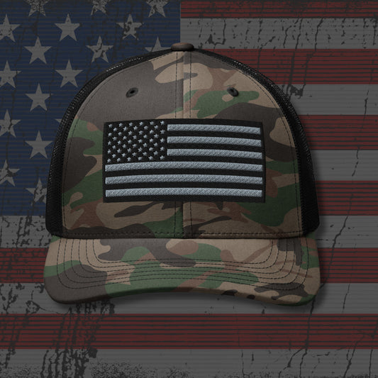 Camouflage cap with American flag patch on an American flag background
