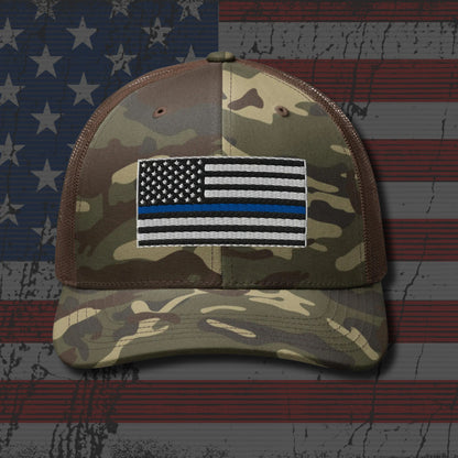 Camouflage cap with a Thin Blue Line patch on an American flag background