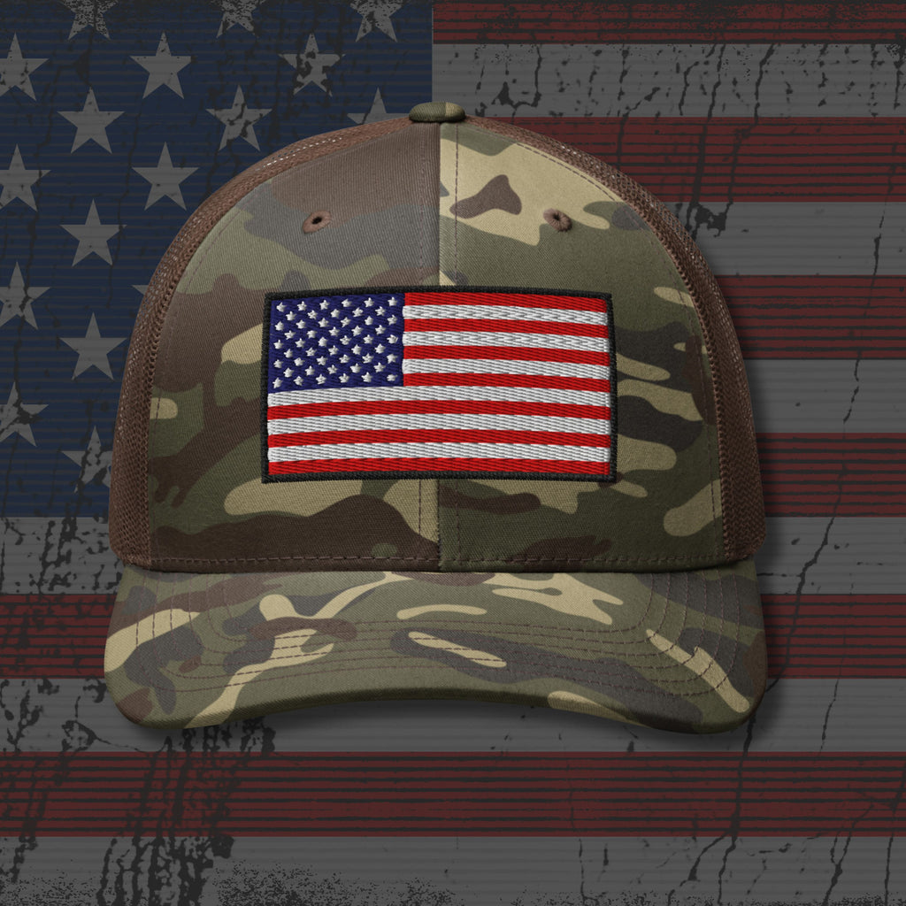Camouflage cap with American flag patch on a background resembling the American flag.