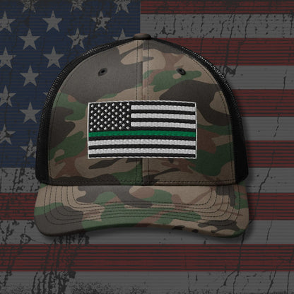 Camouflage cap with American flag patch on an American flag background
