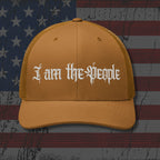 Brown cap with 'I am the People' text on an American flag background
