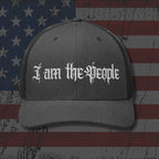 Gray cap with 'I am the People' text on an American flag background
