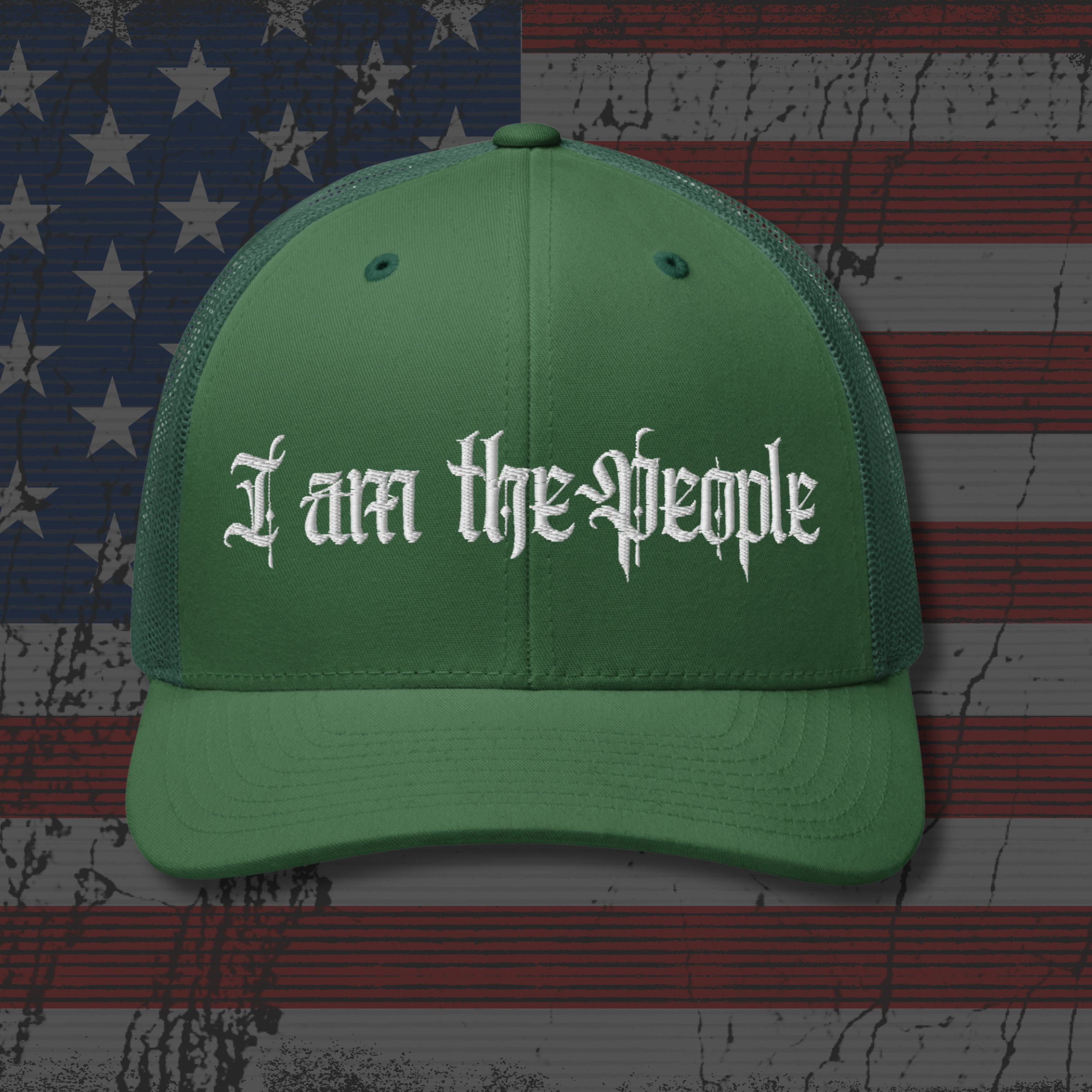 Green cap with 'I am the People' text on an American flag background