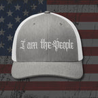 Gray and white cap with 'I am the People' text on an American flag background