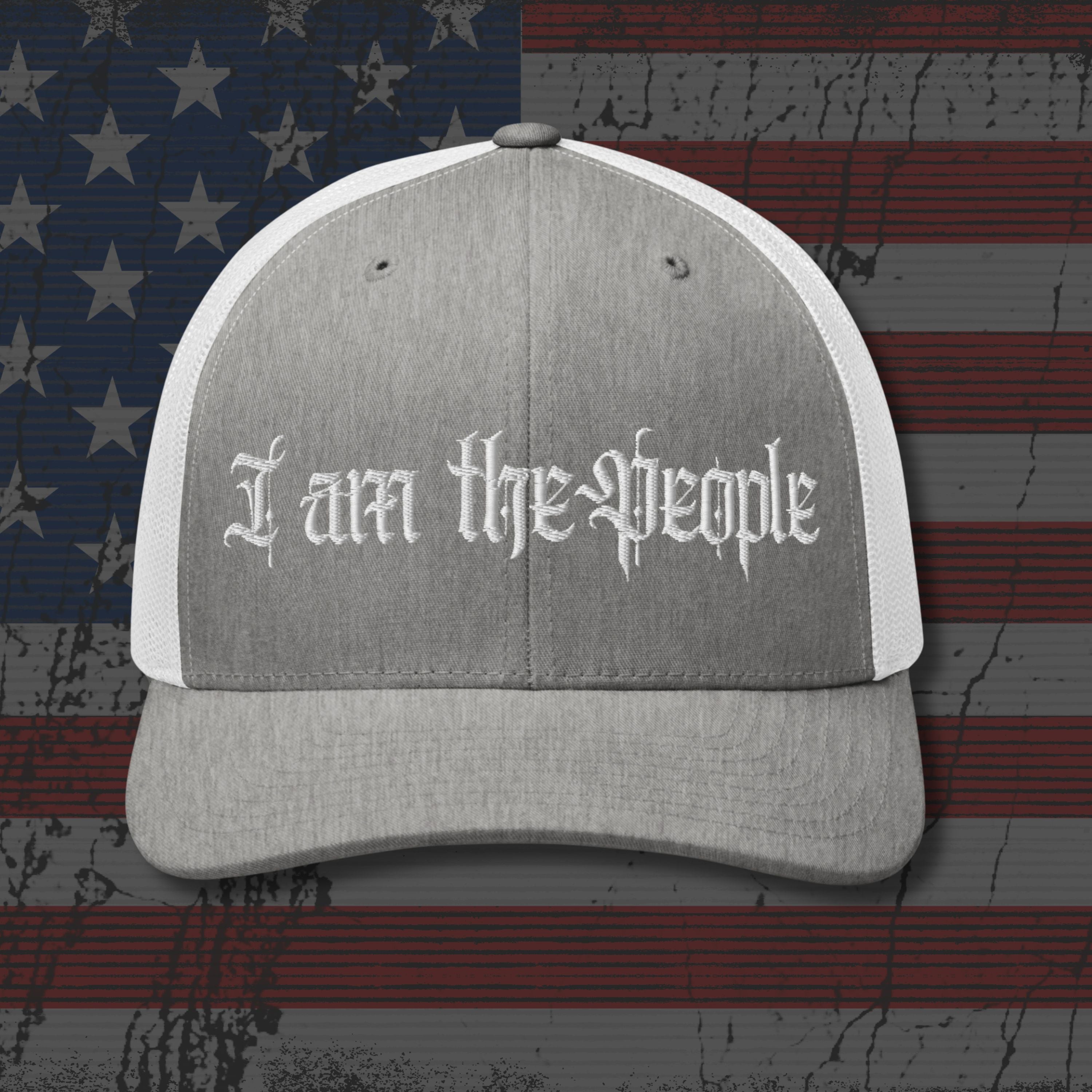 Gray and white cap with 'I am the People' text on an American flag background
