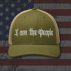 Green cap with 'I am the People' text on an American flag background
