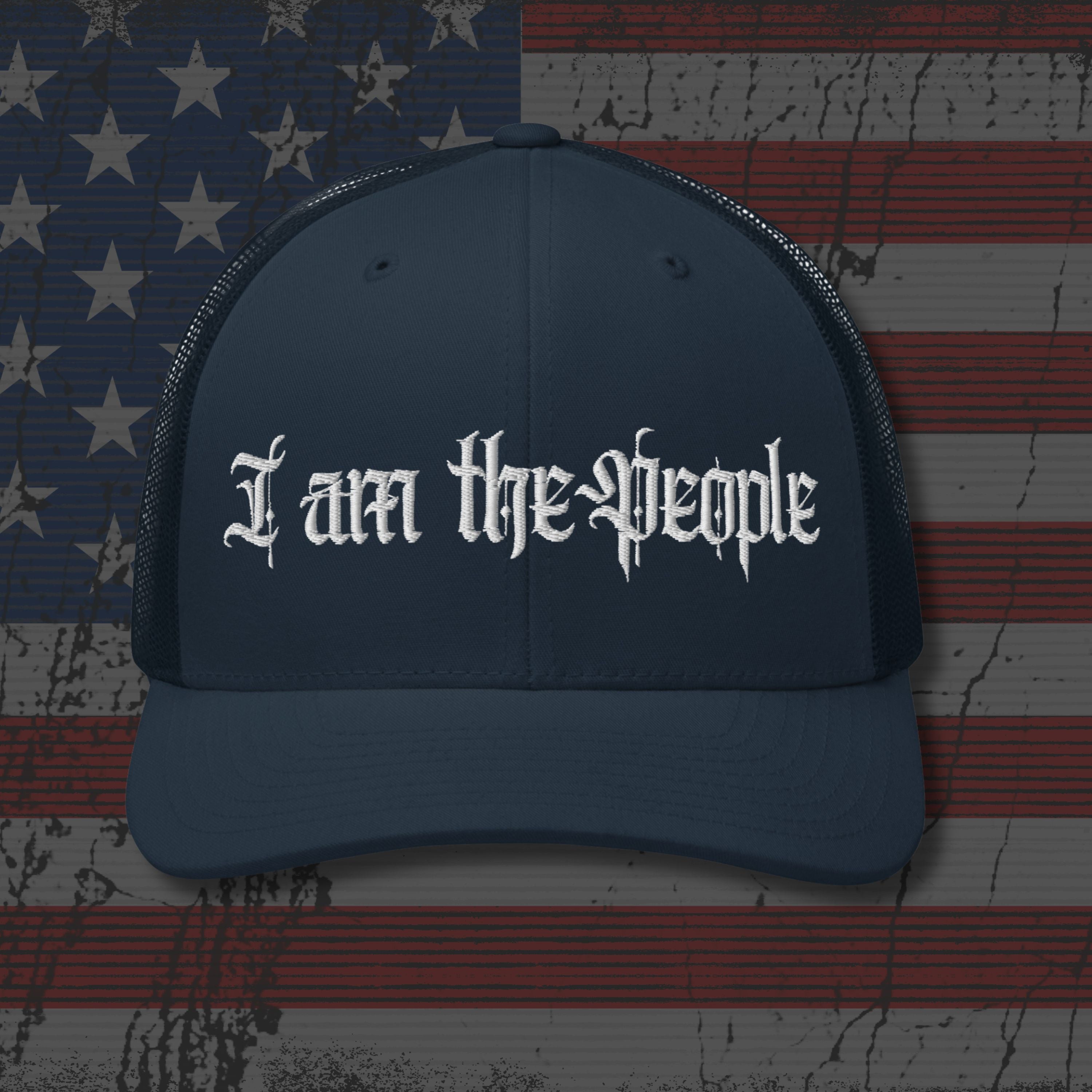 Navy blue cap with 'I am the People' text on an American flag background