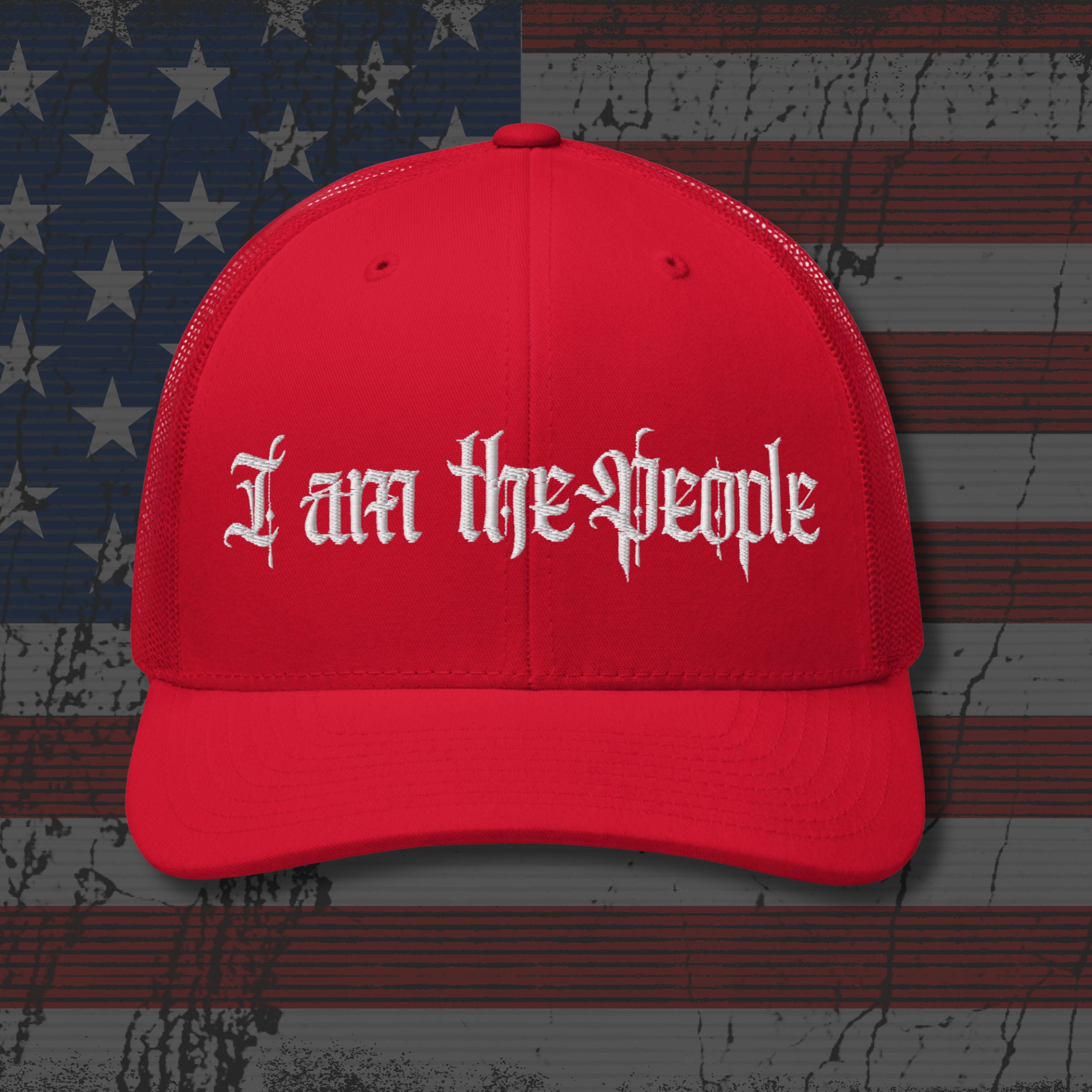 Red cap with 'I am the People' text on an American flag background