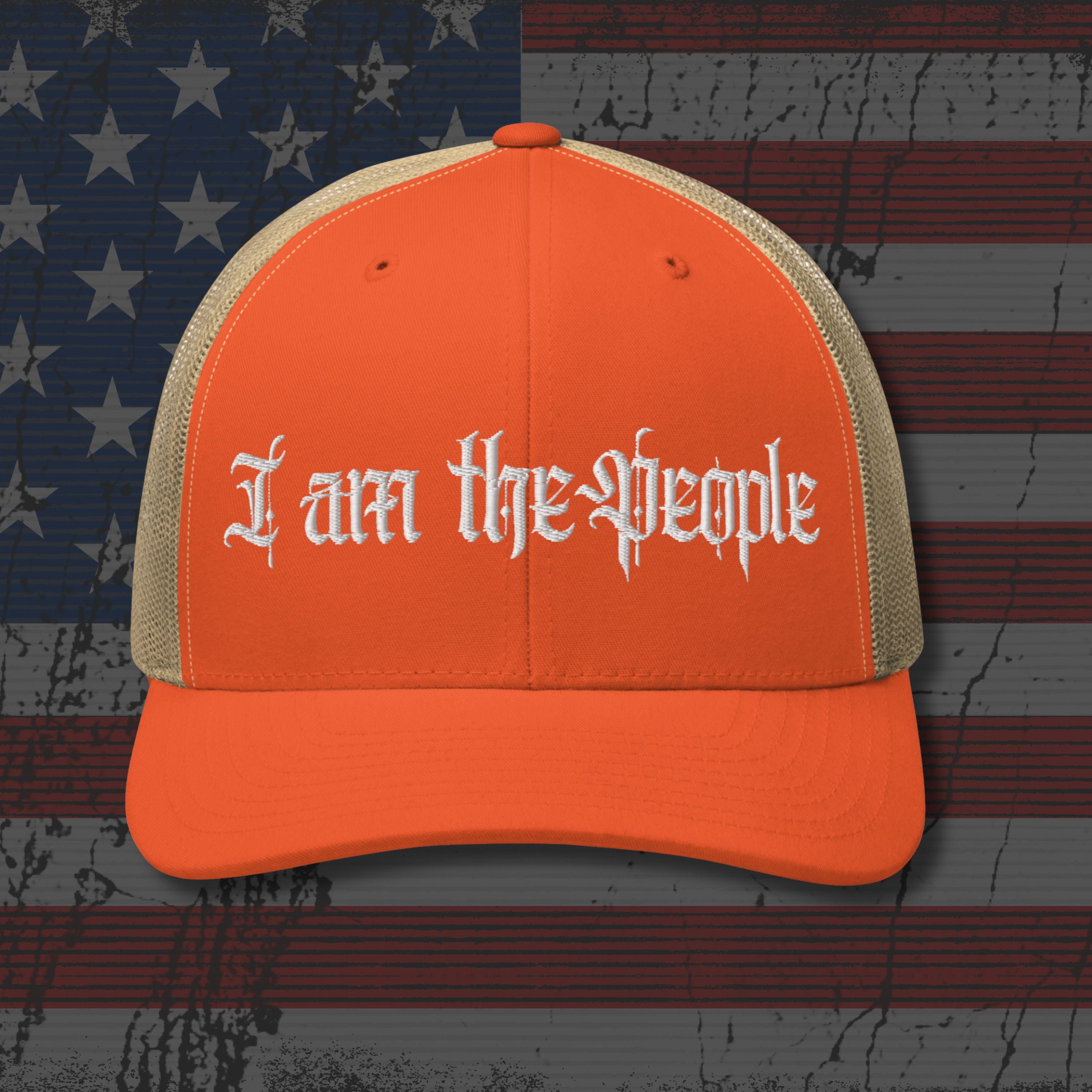 Orange cap with 'I am the People' text on an American flag background