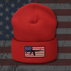 Red beanie with an American flag and gun graphic on a distressed American flag background