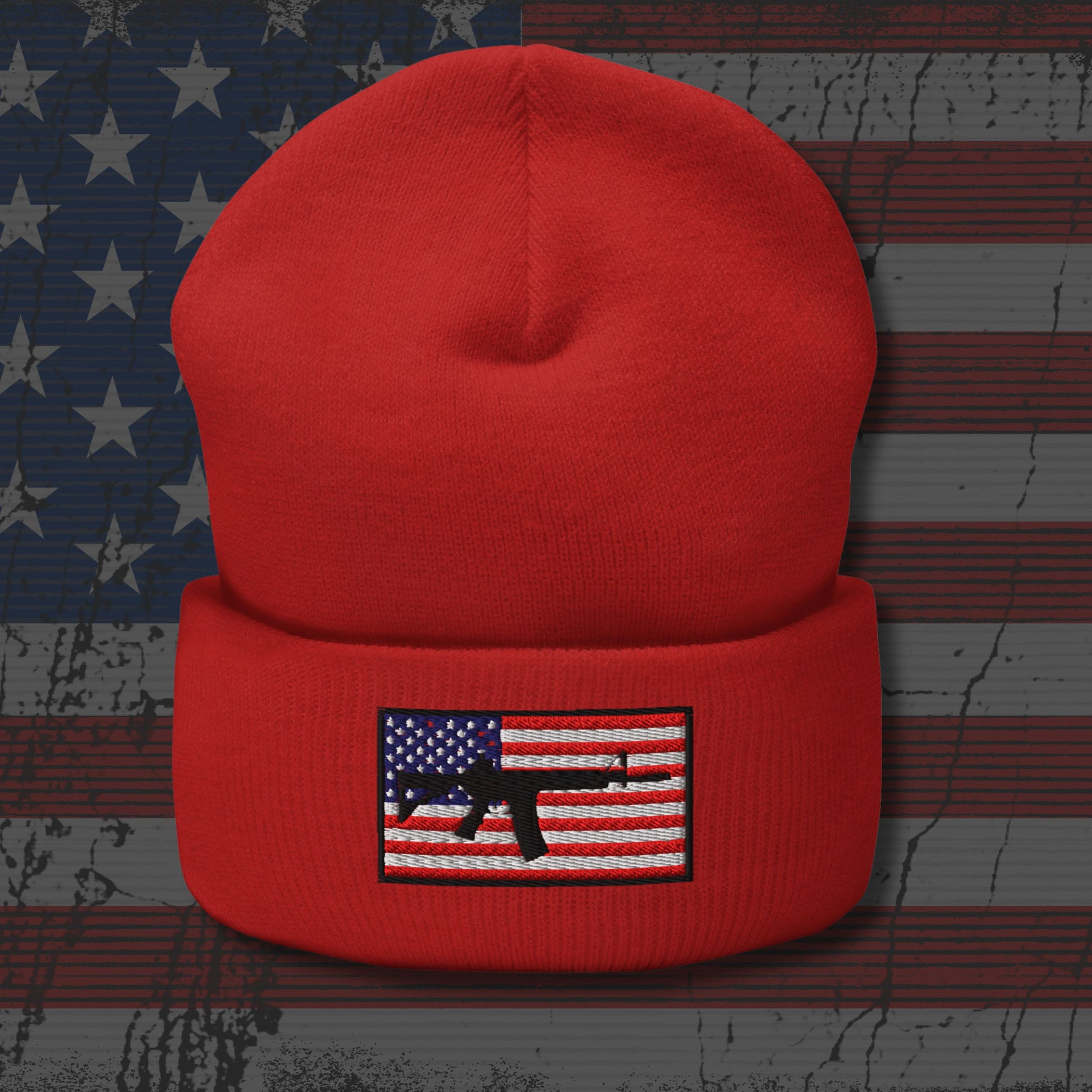 Red beanie with an American flag and gun graphic on a distressed American flag background