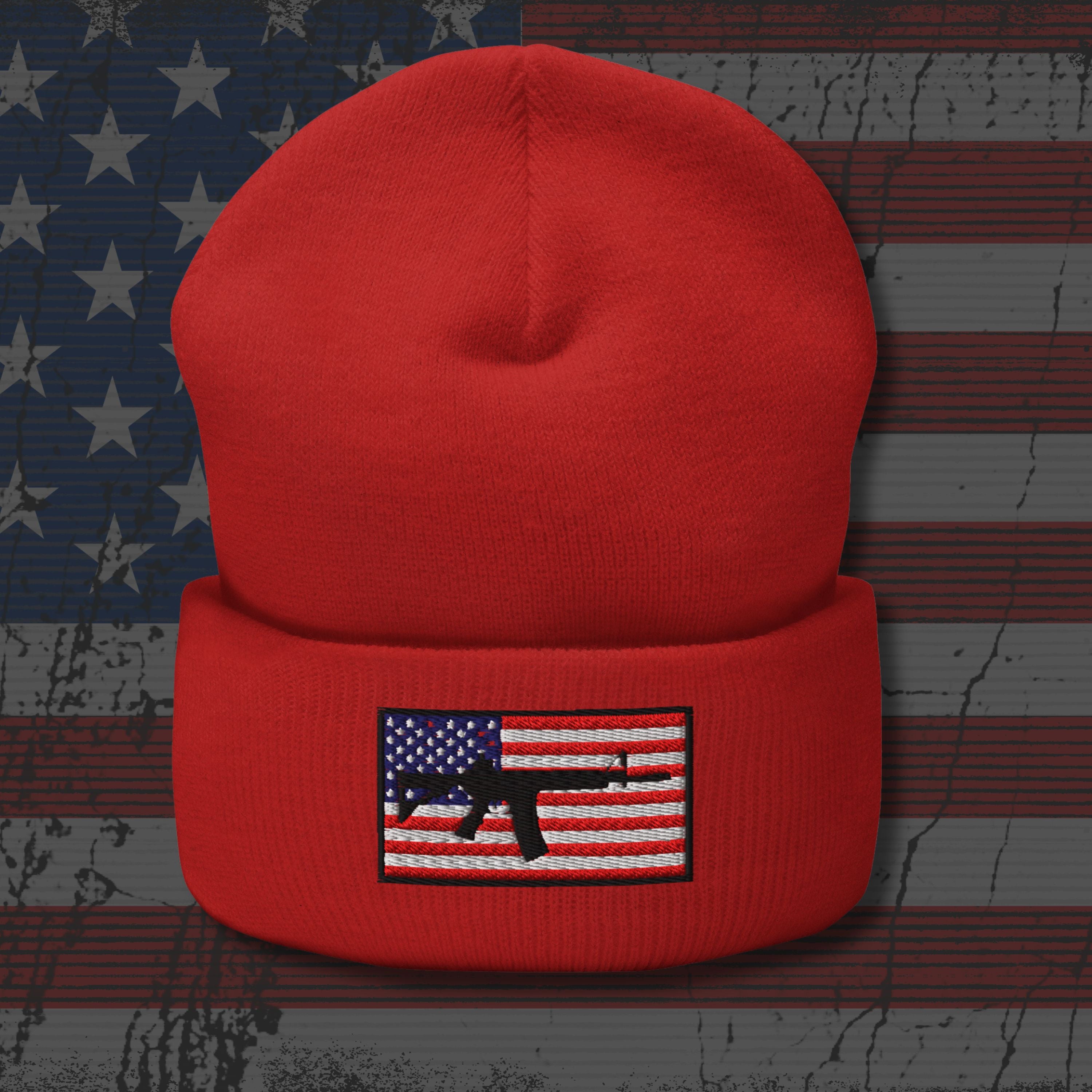 Red beanie with an American flag and gun graphic on a distressed American flag background