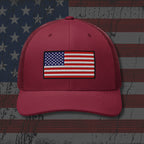 Red cap with American flag patch on a distressed American flag background