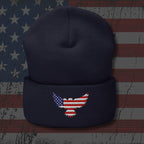 Navy blue beanie with an embroidered American flag eagle design on a textured American flag background.