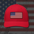 Red cap with American flag patch on a distressed American flag background