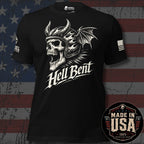 A black short-sleeve graphic T-shirt with a large white skull wearing a horned helmet and bat wings, with the text 'Hell Bent' across the front. The shirt is shown against a distressed American flag background, with a 'Made in USA' badge in the lower right corner.