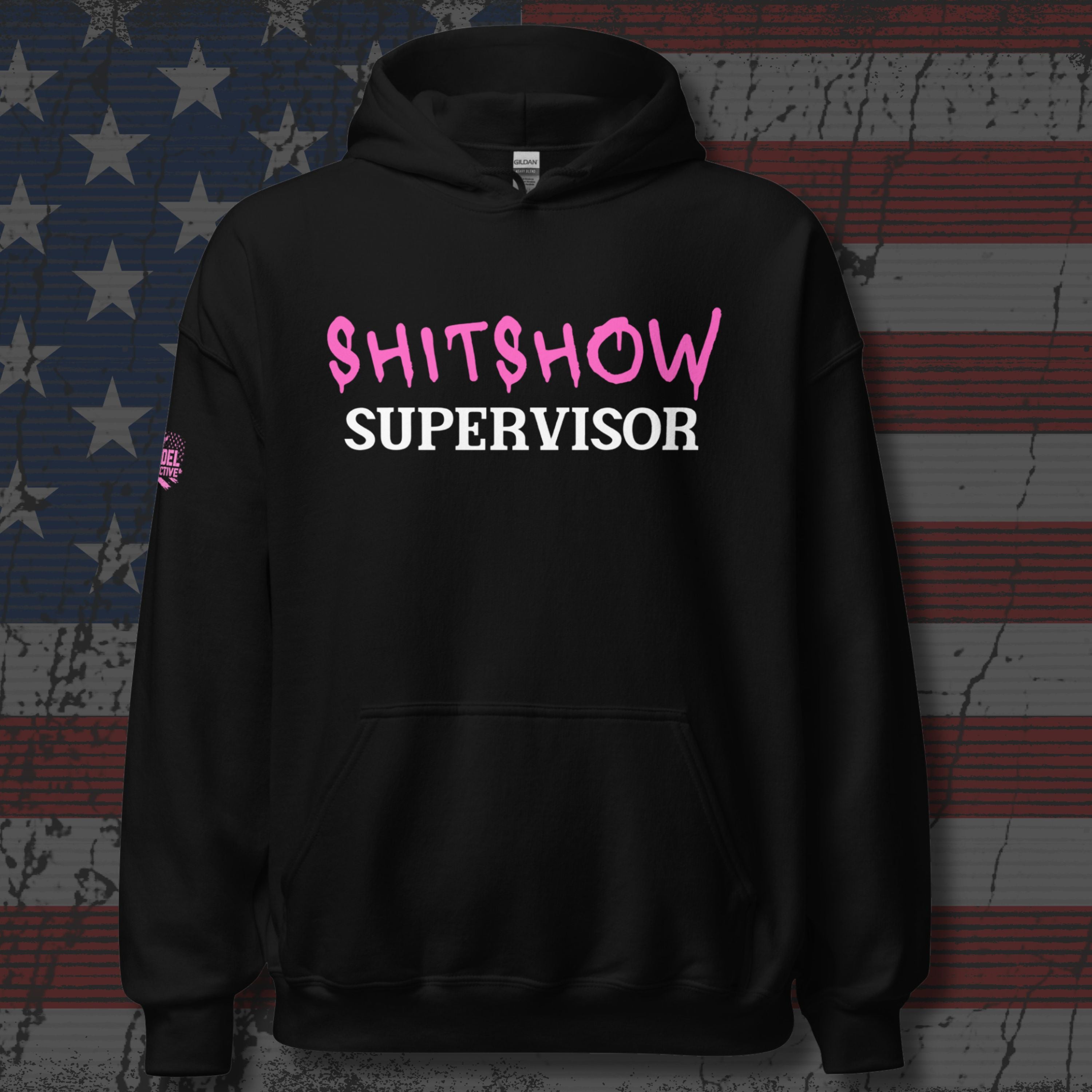 Black hoodie with 'SHITSHOW SUPERVISOR' text in pink and white on a textured background