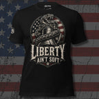 Black tee with front print featuring a rattlesnake wrapped around the Liberty Bell, distressed American flag graphic, and the text Liberty Ain't Soft