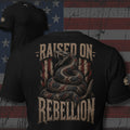 coiled rattlesnake over distressed American flag with Raised on Rebellion text back print black tee from Infidel Collective