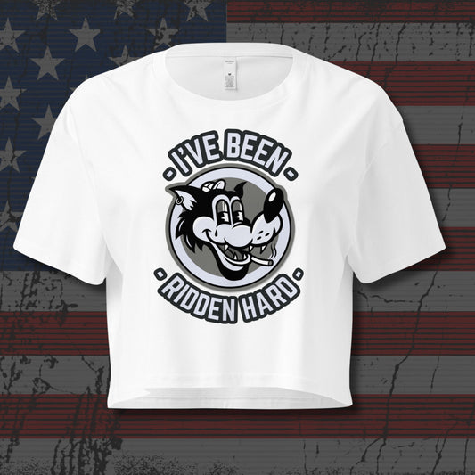 White crop top with graphic and text that says 'I've been ridden hard' on distressed American flag as background 