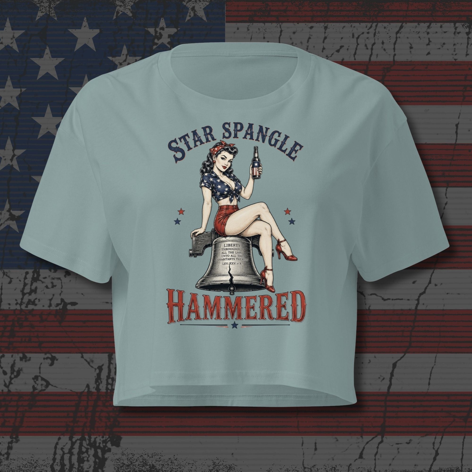 Patriotic pinup woman sitting on the Liberty Bell holding a beer with Star Spangle Hammered text on mineral blue front print tee