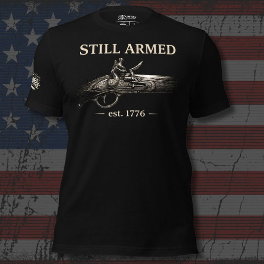Black t-shirt with 'Still Armed' graphic design on a textured American flag background