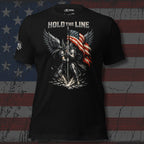 Black t-shirt with a graphic design of a warrior holding an American flag, text 'Hold the Line', on a background resembling an American flag.