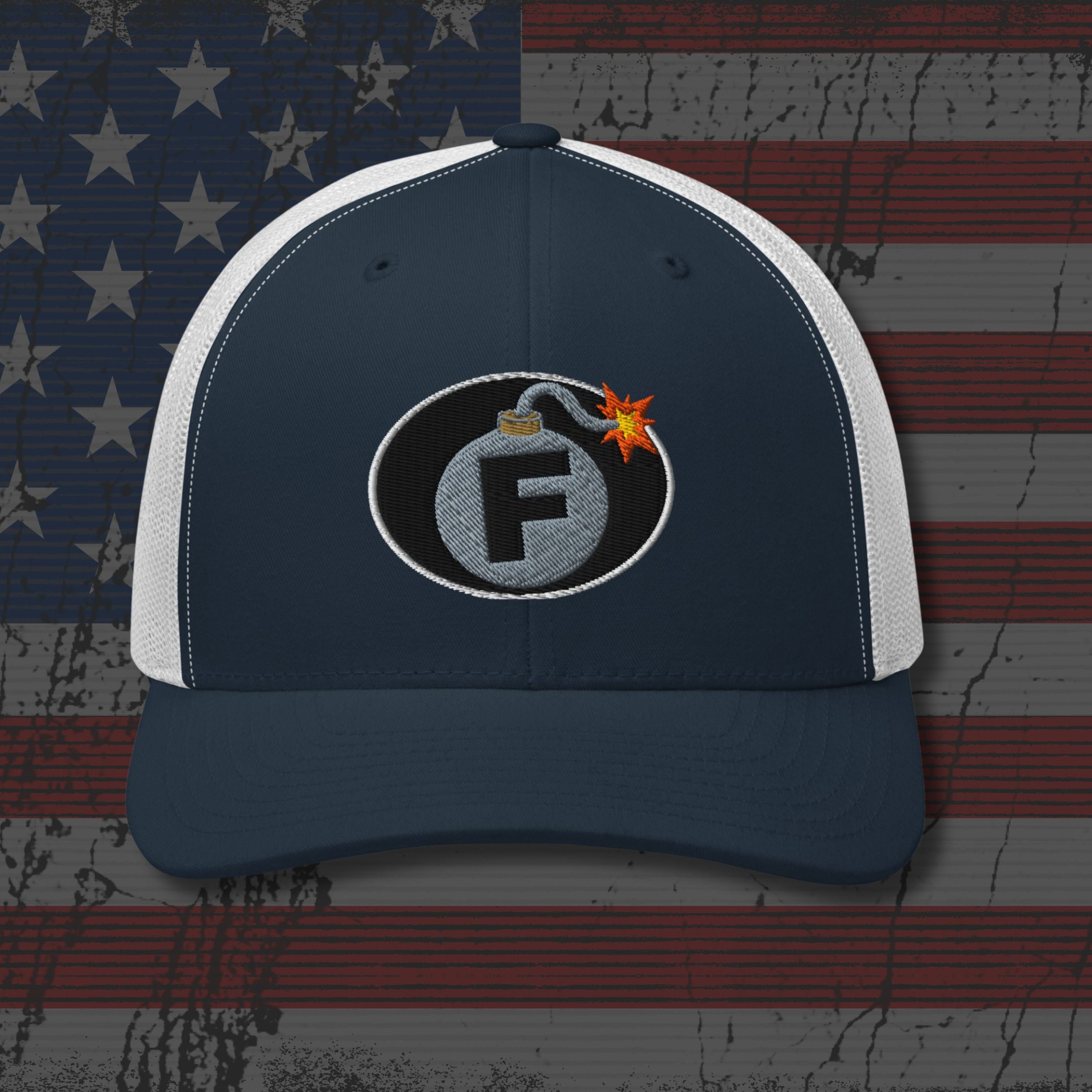 Navy and white cap with a bomb graphic on an American flag background