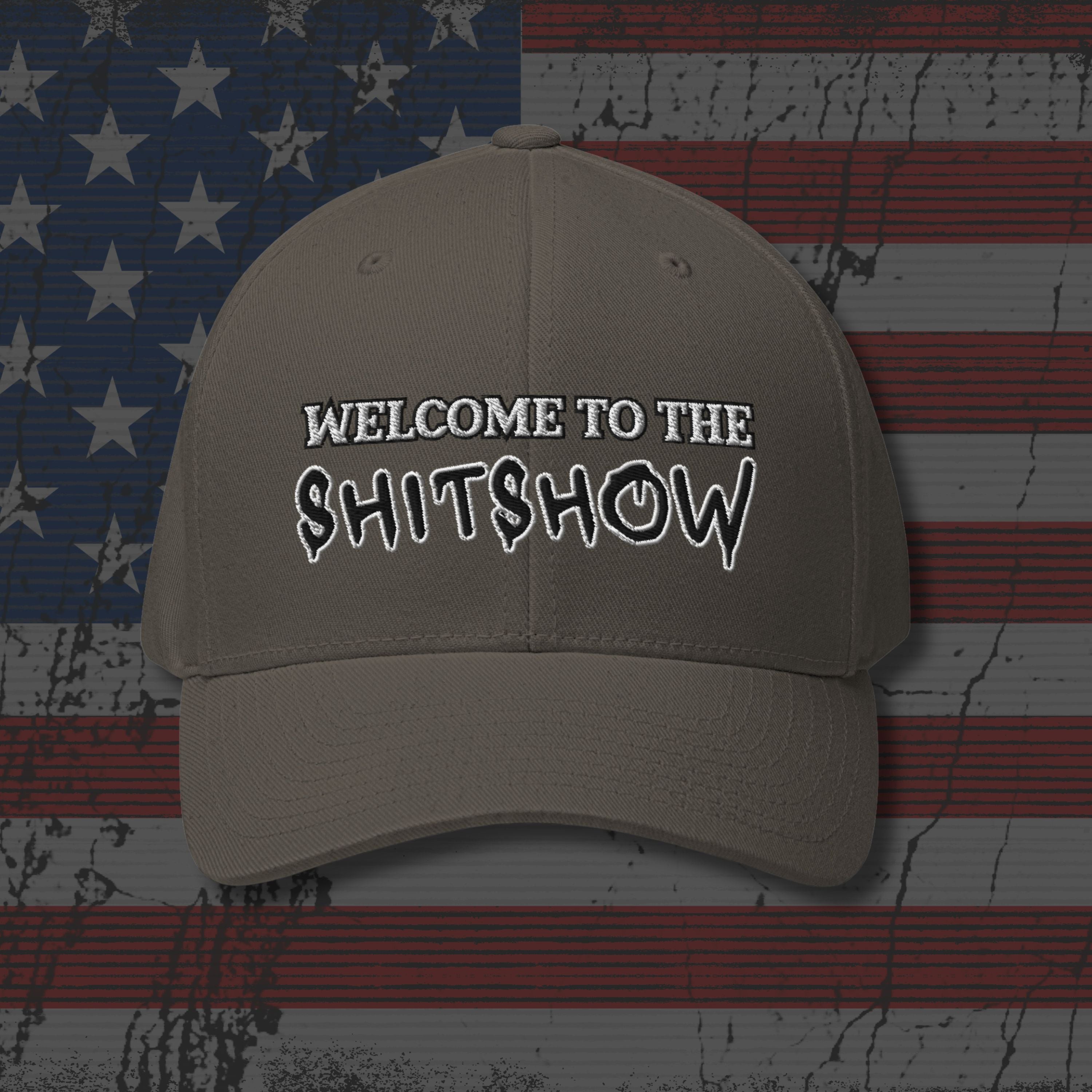 Beige cap with 'WELCOME TO THE SHITSHOW' text on an American flag background