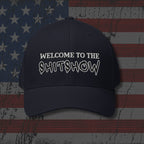 Black cap with 'WELCOME TO THE SHITSHOW' text on an American flag background