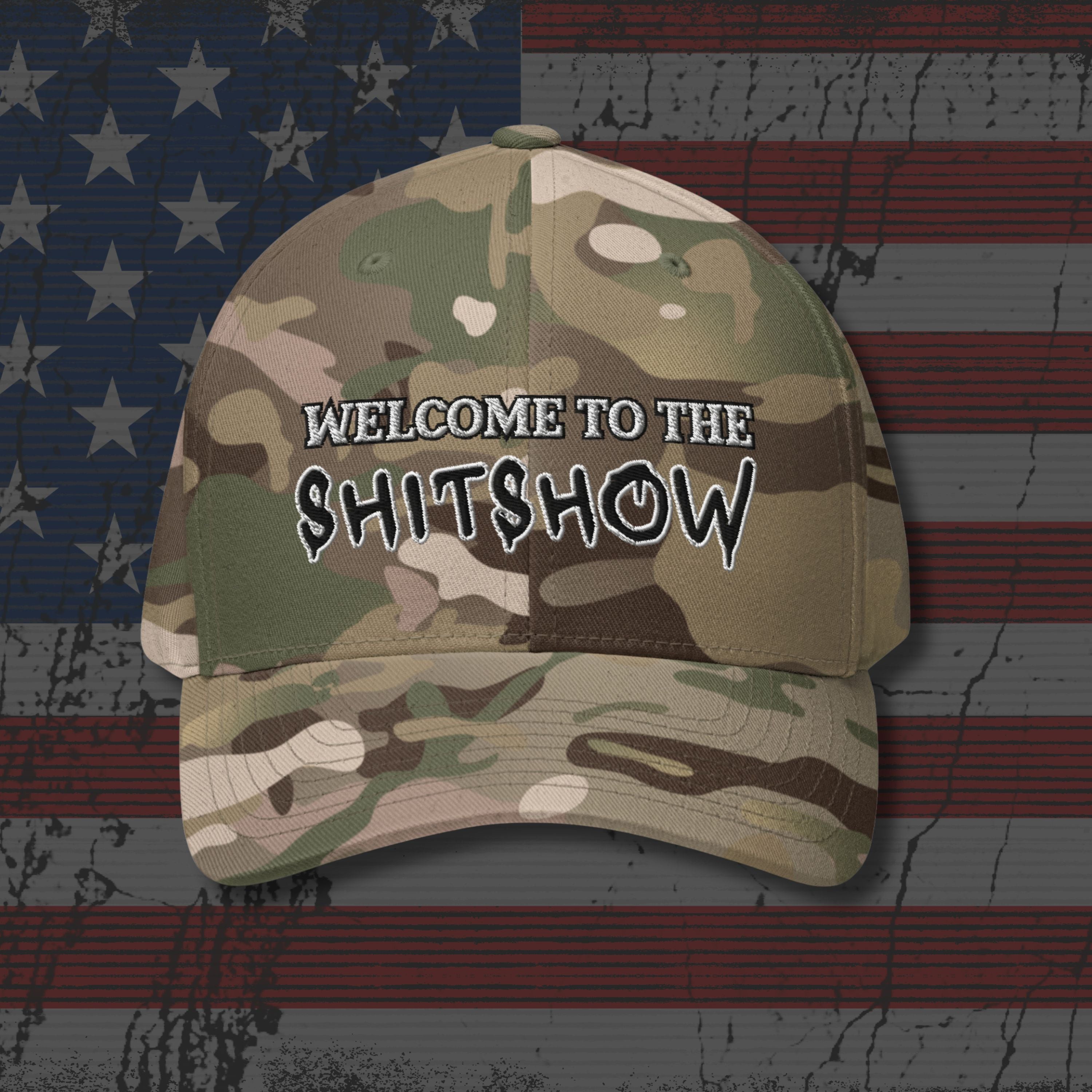 Camouflage cap with 'Welcome to the Sh!tshow' text on an American flag background