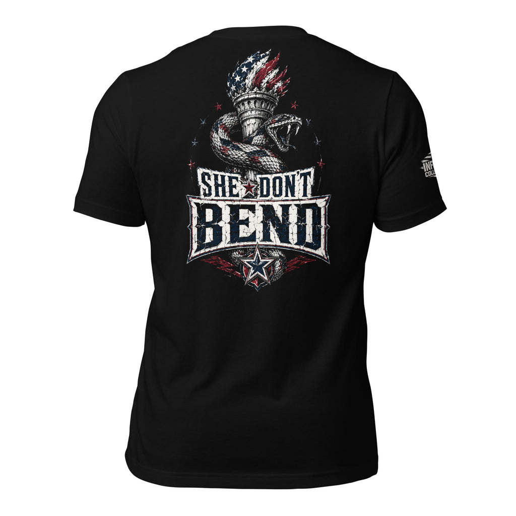 Black tee with back print featuring a rattlesnake wrapped around the Statue of Liberty torch and the text She Don't Bend in distressed patriotic lettering