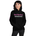 Woman wearing a black hoodie with pink and white SHITSHOW SUPERVISOR text on a white background from Infidel Collective