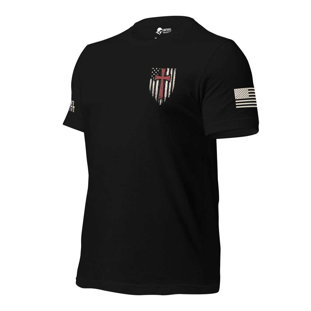 Front left view of black tee with small American flag shield and crimson red cross on the left chest. The left sleeve has an American (USA) flag and the right sleeve brand logo for INFIDEL COLLECTIVE.